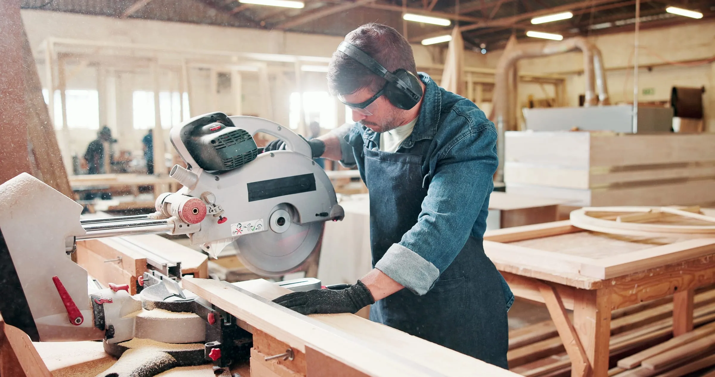 Timmerman zaagt hout in zijn werkplaats